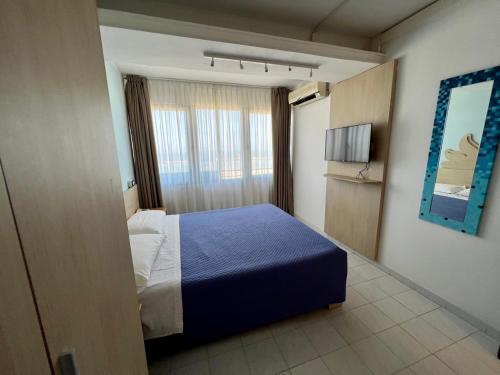una camera con un letto blu e una finestra di Hotel Giorgetti Orange a Bellaria-Igea Marina