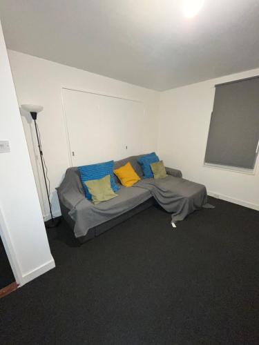 1 dormitorio con 1 cama con almohadas azules y amarillas en Barbara’s Apartment, en Londres
