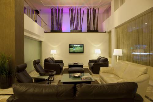 a living room with a couch and chairs and a tv at Susuzlu Atlantis Hotel in Izmir