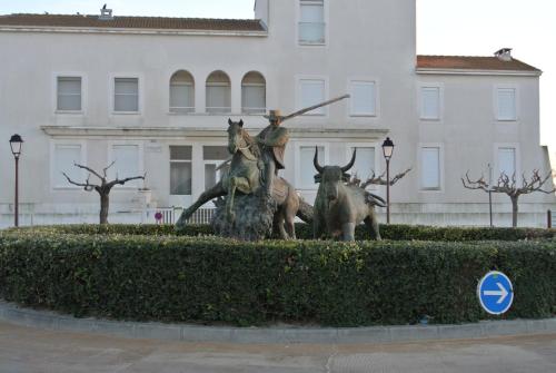 a statue of two animals in front of a building at Hotel Les Palmiers En Camargue in Saintes-Maries-de-la-Mer
