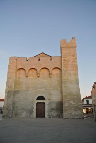 a large brick building with a door in it at Hotel Les Palmiers En Camargue in Saintes-Maries-de-la-Mer