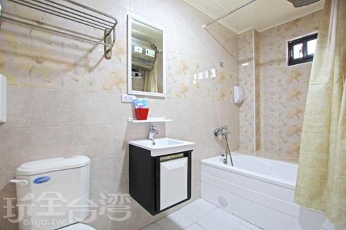 a bathroom with a toilet and a sink and a tub at Miaoli Sanyi Shantongyazhu Homestay in Sanyi