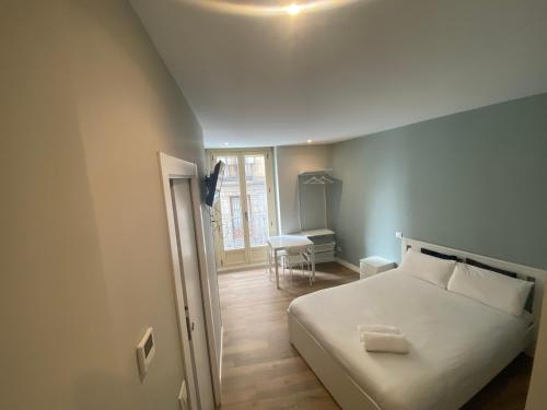 ein Schlafzimmer mit einem Bett, einem Tisch und einem Stuhl in der Unterkunft Apartamentos Sol Madrid in Madrid