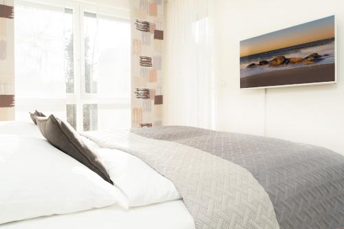Schlafzimmer mit einem Bett und einem TV an der Wand in der Unterkunft Strandvilla Augustusbad Morgenstern in Scharbeutz