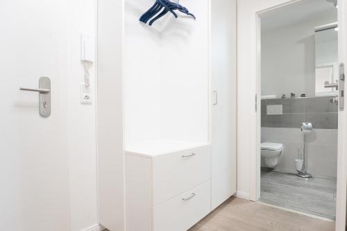 ein weißes Bad mit einem WC und einem Waschbecken in der Unterkunft Strandvilla Augustusbad Morgenstern in Scharbeutz
