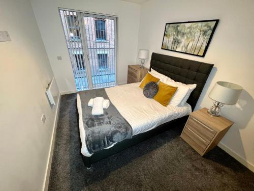 a bedroom with a bed with a cat on it at Halo Apartments - City Centre in Manchester