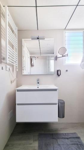 a white bathroom with a sink and a mirror at Apartamento Torre Buena Vista in Torrevieja