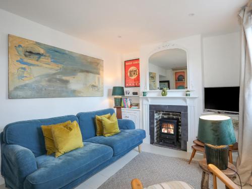 a blue couch in a living room with a fireplace at Seagull Cottage in Beaumaris