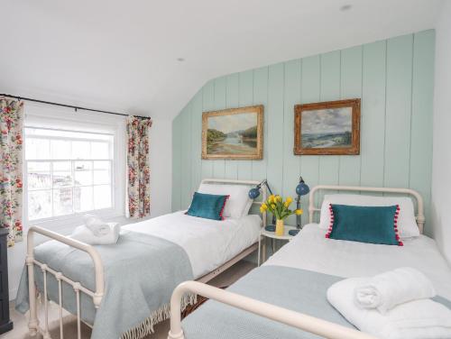 2 Einzelbetten in einem Zimmer mit Fenster in der Unterkunft Seagull Cottage in Beaumaris
