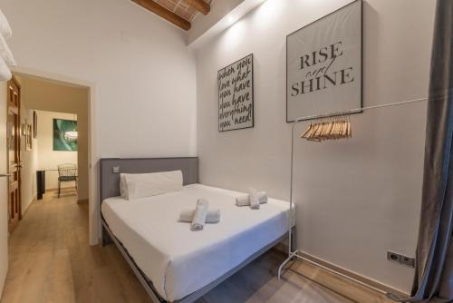 a small bedroom with a bed and a mirror at Centric Gracia Apartments in Barcelona