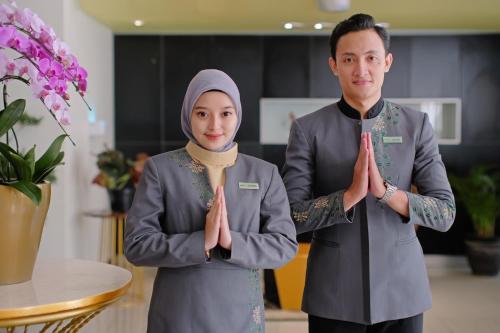 a man and woman standing in a room with their hands up at KHAS Semarang Hotel in Semarang