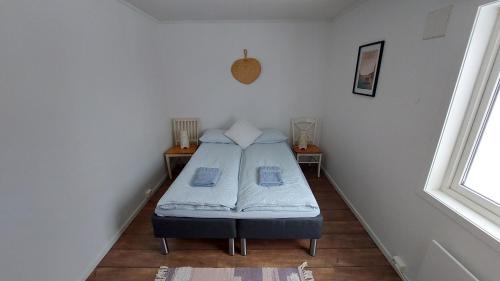 Un pequeño dormitorio con una cama en la esquina en Cozy Apartment between sea and mountains, en Mefjordvær