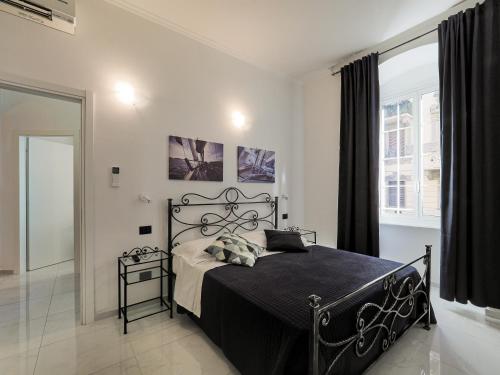 a bedroom with a black bed and a window at ELI&FRA2 in La Spezia