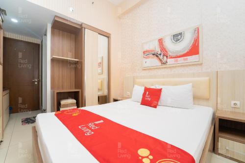 a hotel room with a bed with a red blanket on it at RedLiving Apartemen Vivo Yogyakarta - WM Property in Yogyakarta