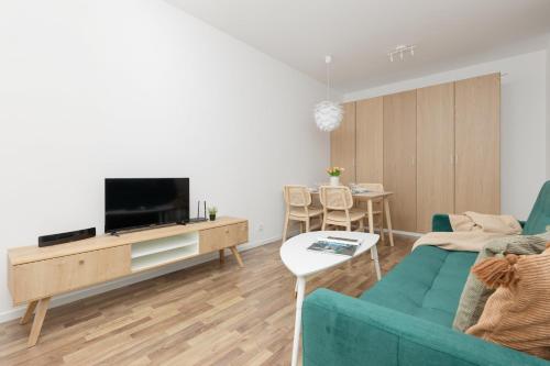 ein Wohnzimmer mit einem Sofa und einem TV in der Unterkunft Stacja Wola Apartments with Parking by Renters in Warschau