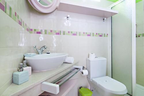 a white bathroom with a sink and a toilet at Blue Sky Apartment in Faro