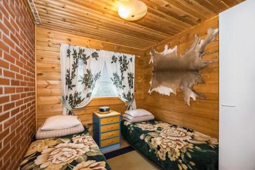 een kamer met 2 bedden en een raam in een hut bij Metsämökki in Kelkala