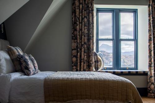 a bedroom with a bed and a window at The Albannach in Lochinver