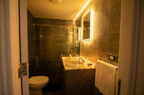a bathroom with a sink and a toilet and a mirror at El Gouna Elite Worldwide Sea & Garden Residences - Hurghada, Egypt in Hurghada