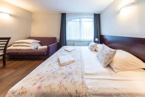 a bedroom with a large bed and a couch at Apartamenty i pokoje ,,Leśne" in Jastarnia
