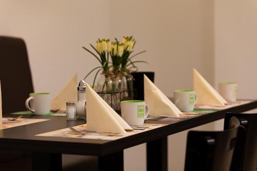 Una mesa con cartas y un jarrón de flores. en Hotel NordRaum, en Bremen