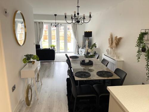 a dining room and living room with a table and chairs at Cosy Bedrooms in Manchester