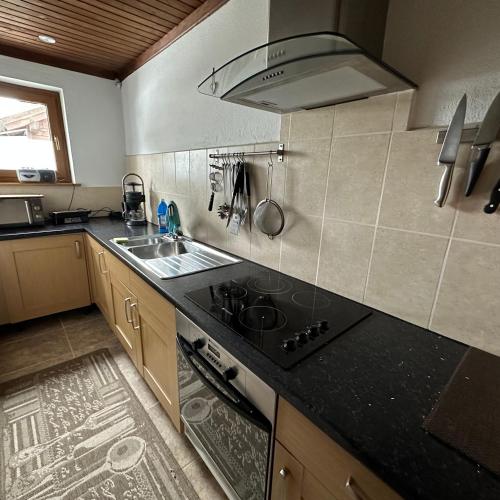a kitchen with a stove top oven next to a sink at Haus Weitblick in Sirnitz-Sonnseite