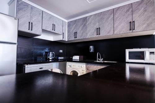 a kitchen with white appliances and a black counter top at El Gouna Elite Worldwide Sea & Garden Residences - Hurghada, Egypt in Hurghada