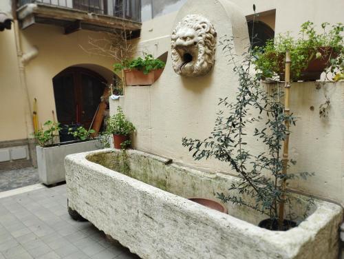 a stone tub with a face on the side of a building at La corte di Frascati in Frascati