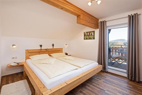 a bedroom with a bed and a large window at Ferienhof Weishäupl in Untergriesbach