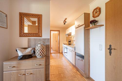 a kitchen with wooden floors and a large mirror at Ferienhof Weishäupl in Untergriesbach