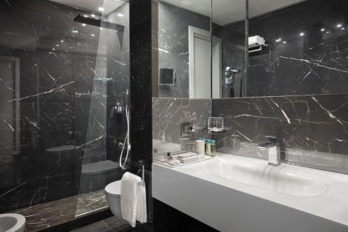 a bathroom with a tub and a sink and a toilet at LHP Napoli Palace & SPA in Naples