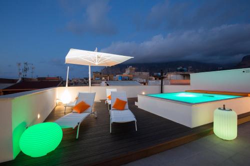 a rooftop deck with a swimming pool and an umbrella at Giada Luxury in Terrasini
