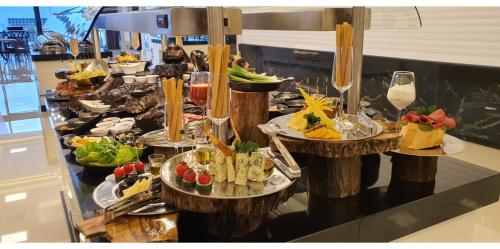 a buffet with many plates of food on a table at Mc Palace Hotel Spa & Convention in Kérynia