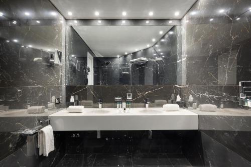a bathroom with a sink and a large mirror at LHP Napoli Palace & SPA in Naples