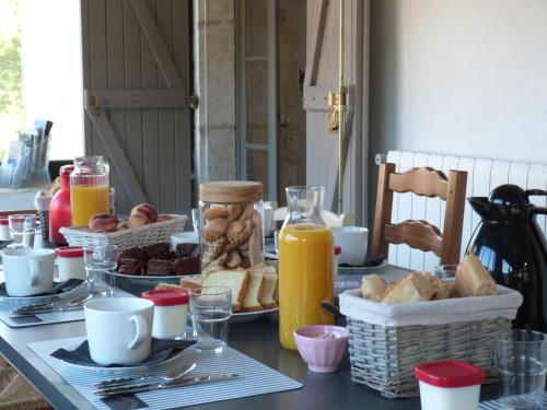 a table with a breakfast of bread and orange juice at La Gariotte in Esclauzels