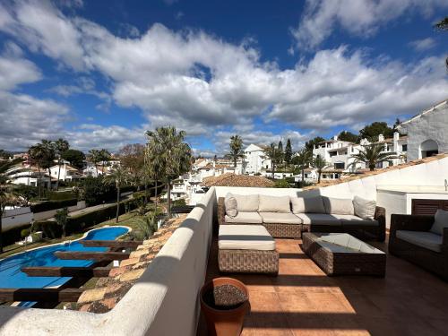 a patio with couches and a swimming pool at Aldea Blanca Cozy Penthouse in Puerto Banús in Marbella