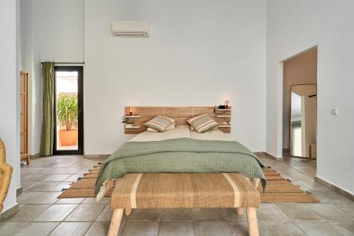 - une chambre avec un lit et une tête de lit en bois dans l'établissement El Cine, à Canillas de Albaida