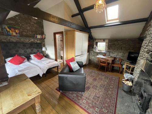 アバーデアにあるTunnel Cottages at Blaen-nant-y-Groes Farmのベッドルーム1室(ベッド1台、ソファ、テーブル付)
