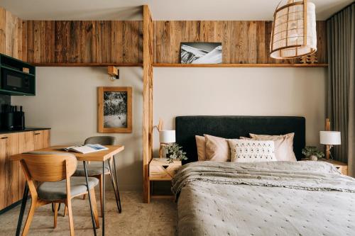 a bedroom with a bed and a table and a desk at Apartamenty Riders Lodge Kościelisko Chotarz Bór in Kościelisko