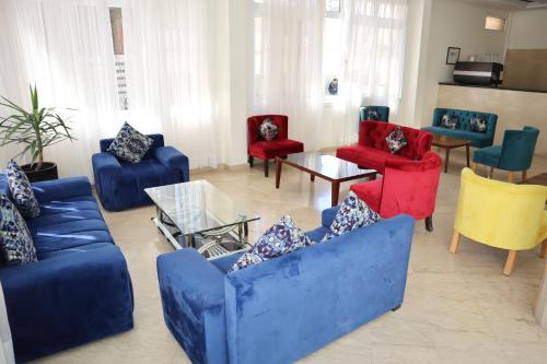 a living room with blue couches and colorful chairs at Boutique Hôtel Albaraka in Dakhla