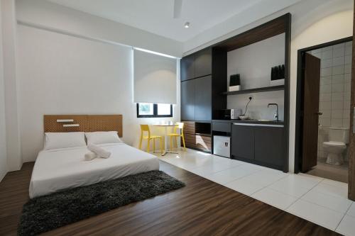 Cet appartement comprend une chambre avec un lit et une cuisine avec une table. dans l'établissement ALOR SETAR IMPERIO PROFESSIONAL SUITE by Zenith Smart, à Alor Setar