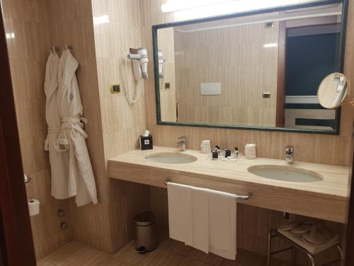 a bathroom with two sinks and a large mirror at Santa Barbara Hotel in San Donato Milanese