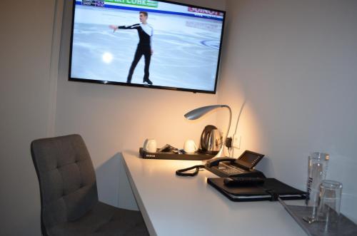 a desk with a laptop and a television on a wall at Ziegenbruch´s Gastronomie in Spenge