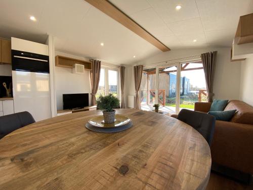 a large wooden table in a living room with a couch at Strandparc Nulde in Putten
