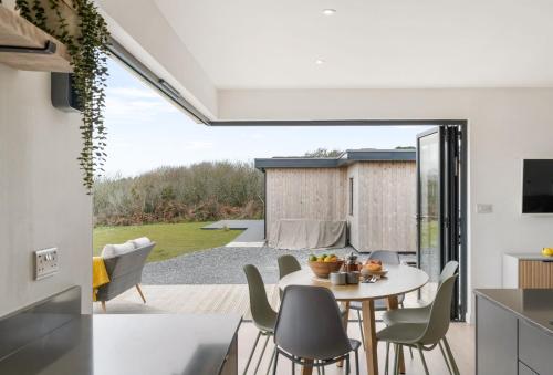 a kitchen and dining room with a table and chairs at Poppyfields in Germoe