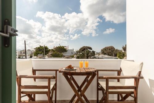 een tafel en stoelen op een balkon met uitzicht bij Sunshine in Naxos Chora