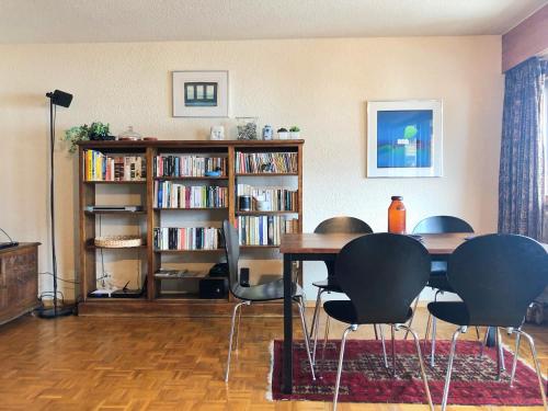 - un salon avec une table, des chaises et une étagère dans l'établissement Appartement à 200m de la télé-cabine de Vercorin, à Vercorin