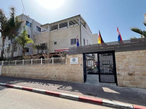 a building with an open door with flags on it at Domus Bat Galim Hotel in Haifa