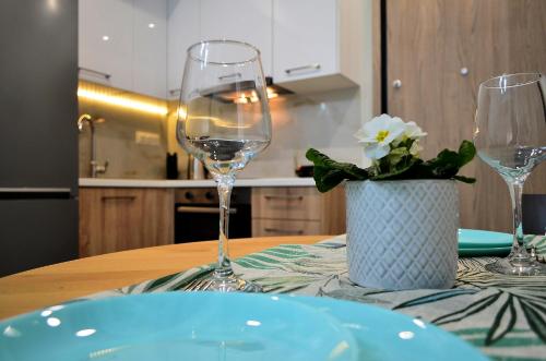 a table with two wine glasses and a vase of flowers at Ippokratio Luxury Apartment in Thessaloniki